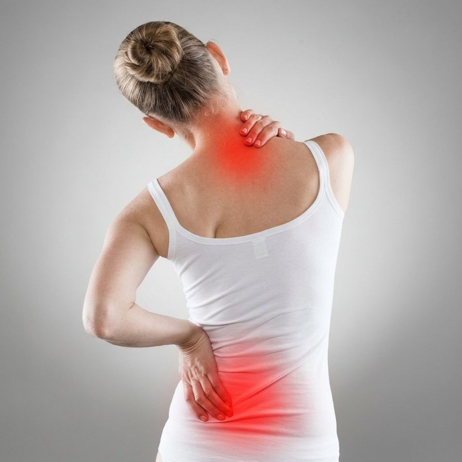 Patient holding their lower back where a disc is pressing on a nerve